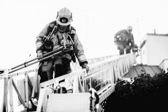 Firefighters climbing on a ladder